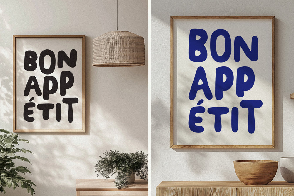 Two framed prints with 'Bon Appetit' text on a wall with a lamp and plant.