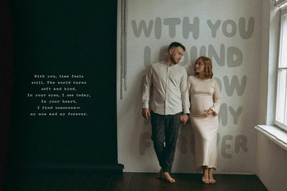 Man and woman standing in a room with quirky text on the wall.